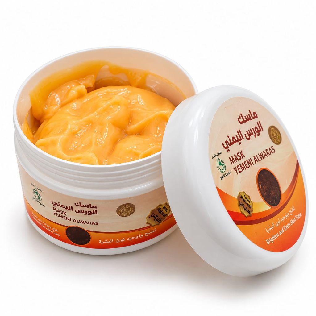 An open white plastic jar of Yemeni Al Waras Mask with its lid leaning against it, showing a thick orange-yellow mask inside. The label features Arabic text, 'Yemeni Al Waras Mask', and a circular gold seal, set against a clean white background.